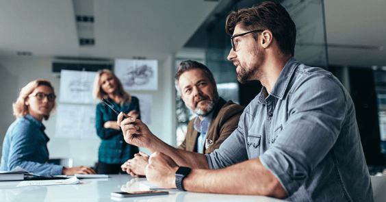 A man discussing business tacts with his colleagues in a meeting.